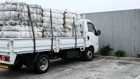 Flatbed truck loaded with bales of plastic scrap.